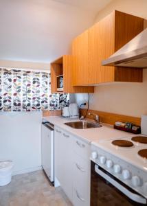 kuchnia z białymi szafkami i zlewem w obiekcie Merivale Court Motel & Apartments w mieście Christchurch