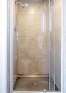 a shower stall with a glass door in a bathroom at Merivale Court Motel & Apartments in Christchurch