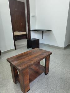 a wooden bench in a room with a table at Shree 53 1BHK in Bangalore