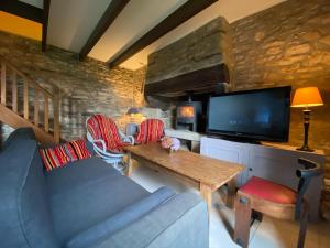een woonkamer met een bank en een tv bij Gite in Ploneour-Lanvern in Plonéour-Lanvern