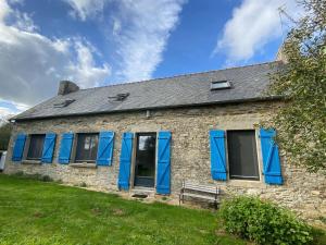 - un vieux bâtiment en pierre avec des volets bleus dans l'établissement Gite in Ploneour-Lanvern, à Plonéour-Lanvern