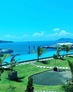 a large swimming pool with a view of the ocean at Jesselton Quay - Suite 1 by Staycation Suites KK in Kota Kinabalu
