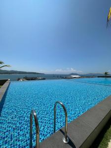 a swimming pool with a view of the water at Jesselton Quay - Suite 1 by Staycation Suites KK in Kota Kinabalu