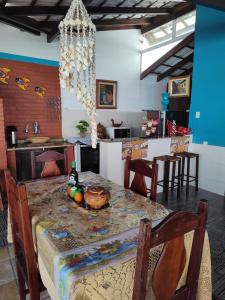 a kitchen with a table with a bowl of fruit on it at suites com piscina praia dos anjos in Arraial do Cabo