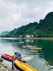 Un groupe de personnes dans des bateaux dans l'eau dans l'établissement Funny Monkeys Homestay, à Phong Nha