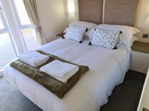 Un dormitorio con una cama blanca con almohadas y una ventana en Bock Retreat Lodge 54 with Hot Tub, en Felton