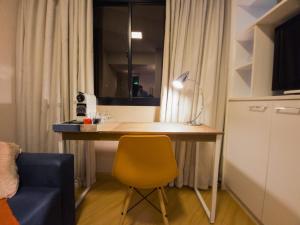 a desk in a room with a yellow chair at The Best Deluxe - Duplex Studio - Hotel Slav Moema - by LuXXoR in Sao Paulo