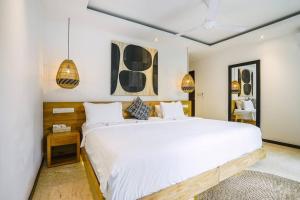 Un pat sau paturi într-o cameră la Frangipani Villa Mawe at Berawa +61 fotografii