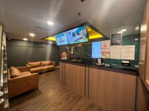ein Restaurant mit einer Bar mit einem Sofa und einer Theke in der Unterkunft Seeds Hotel Chow Kit in Kuala Lumpur