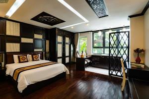 a bedroom with a bed and a desk and a window at Wild Lotus Hotel Apartment 2 in Hanoi