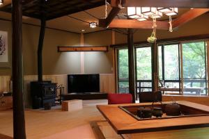 ein Wohnzimmer mit einem Tisch und einem TV in der Unterkunft 那須リゾートMomiji 貸切 in Nasu
