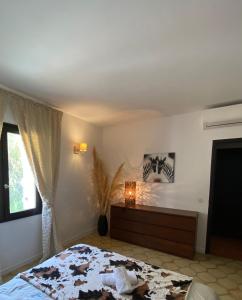 a bedroom with a bed and a dresser and a window at Villa Marie Cap Corse sentier douaniers in Centuri