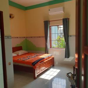 sypialnia z łóżkiem i oknem w obiekcie San Vuon Guesthouse w mieście Mui Ne