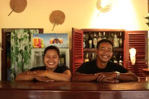 two men sitting at a counter in a bar at Sambor Village Hotel in Kompong Thom