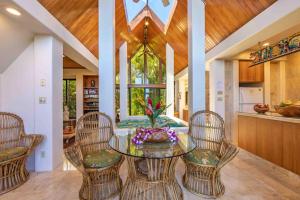 jadalnia ze szklanym stołem i krzesłami w obiekcie Lavish Cliff House with Ocean Views in Haiku, Maui jungle w mieście Huelo