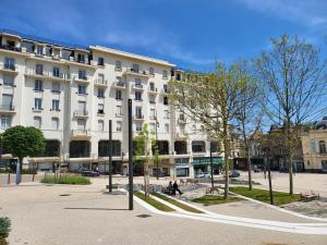 a large white building on a city street at Studio meublé classé à Chatel Guyon ville thermale in Châtel-Guyon