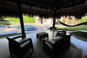 a patio with chairs and a hammock and a pool at comfortable country house in Pereira