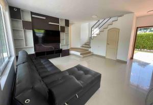 - un salon avec un canapé en cuir noir et un escalier dans l'établissement comfortable country house, à Pereira