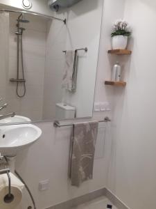 a white bathroom with a sink and a mirror at Matrix Garden Apartments in Tallinn