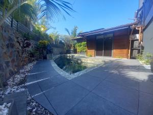 a swimming pool in a yard next to a house at Vert Lagon in La Saline les Bains