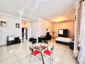 um quarto com uma mesa e cadeiras e uma cama em OASE GUEST HOUSE em Medan