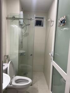 a bathroom with a toilet and a glass shower at SNOW`S HOUSE in Ho Chi Minh City