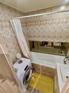 uma máquina de lavar roupa na casa de banho com um espelho em Dream Apartment em Jelgava