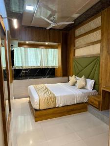 a bedroom with a bed with a green headboard at HOTEL BKC PRIME - NEAR US CONSULATE in Mumbai