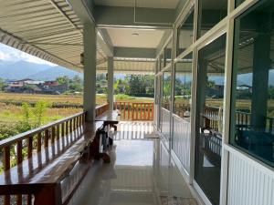 a porch with benches and a view of the mountains at มองภู โฮมสเตย์ in Ban Fang