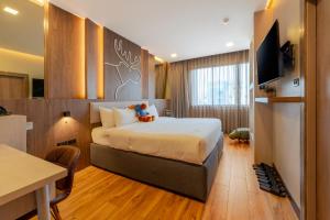 a hotel room with a bed with teddy bears on it at Moose Hotel Chiangmai in Chiang Mai