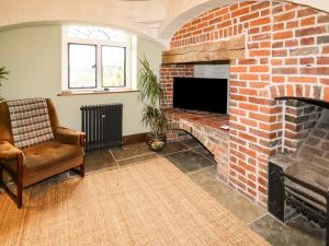 a living room with a brick fireplace with a television at Riverview Apartment in Bridgnorth