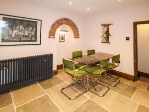 Riverview Apartment في بريدغنورث: غرفة طعام مع طاولة وكراسي خضراء