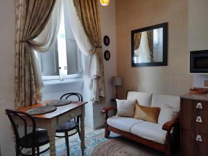 ein Wohnzimmer mit einem Sofa, einem Tisch und einem Fenster in der Unterkunft Bizzilla Lodging Suite in Mqabba