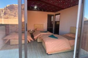 3 camas en una habitación con vistas al desierto en Welcome to Wadi Rum Camp, en Wadi Rum 252 fotos más