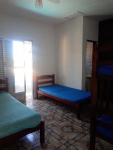 een kleine kamer met 2 bedden en een raam bij Casa aconchegante de praia in Itanhaém