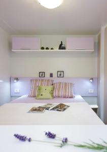 Un dormitorio con una cama con flores púrpuras. en Sárvár Fürdő Mobilházak en Sárvár