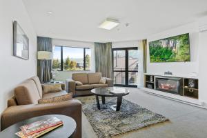 a living room with a couch and a fireplace at Village Lake Apartments in Hanmer Springs
