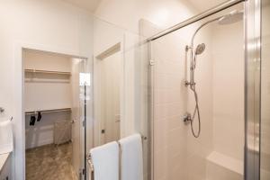 a bathroom with a shower with white tiles at 5mins to Disney/3 Bedroom House with Pool in Anaheim