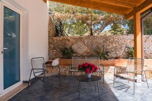 eine Terrasse mit Stühlen und einem Tisch mit Blumen darauf in der Unterkunft Villa la Giara in Castellammare del Golfo