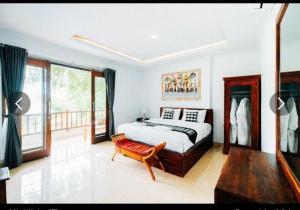 um quarto com uma cama e um banco em Tinggian Hill Retreat em Nusa Penida