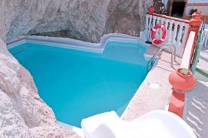 a blue swimming pool in a stone wall at Casa Sendero de Taidia in San Bartolomé de Tirajana