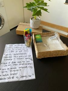 a table with a handwritten note next to a basket at Happy Fisherman BnB in Aalborg