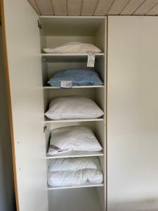 a closet with white shelves with pillows in it at Happy Fisherman BnB in Aalborg