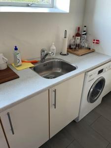 a kitchen with a sink and a washing machine at Happy Fisherman BnB in Aalborg