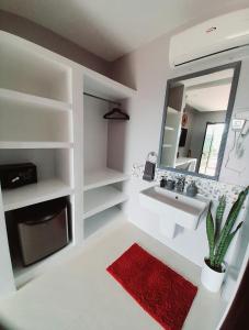 a bathroom with a sink and a mirror and a red rug at RC Villas and Resorts in El Nido