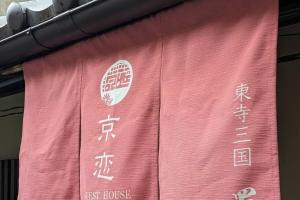 a red banner with asian writing on the side of a building at Kyokoi Toujimikuni in Kyoto
