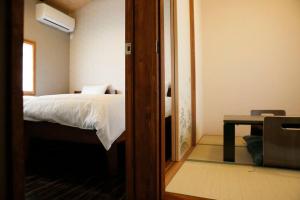 a bedroom with a bed and a table and a mirror at Kyokoi Toujimikuni in Kyoto