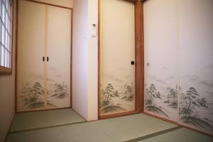 a room with three glass doors with trees on the wall at Kyokoi Toujimikuni in Kyoto