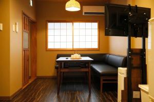 a room with a couch and a table and a window at Kyokoi Toujimikuni in Kyoto