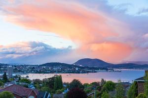 a view of a city and the water with a rainbow at Million Dollar Views in Hobart